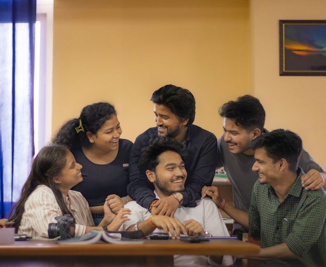 A group of cheerful Indian college students around a study table